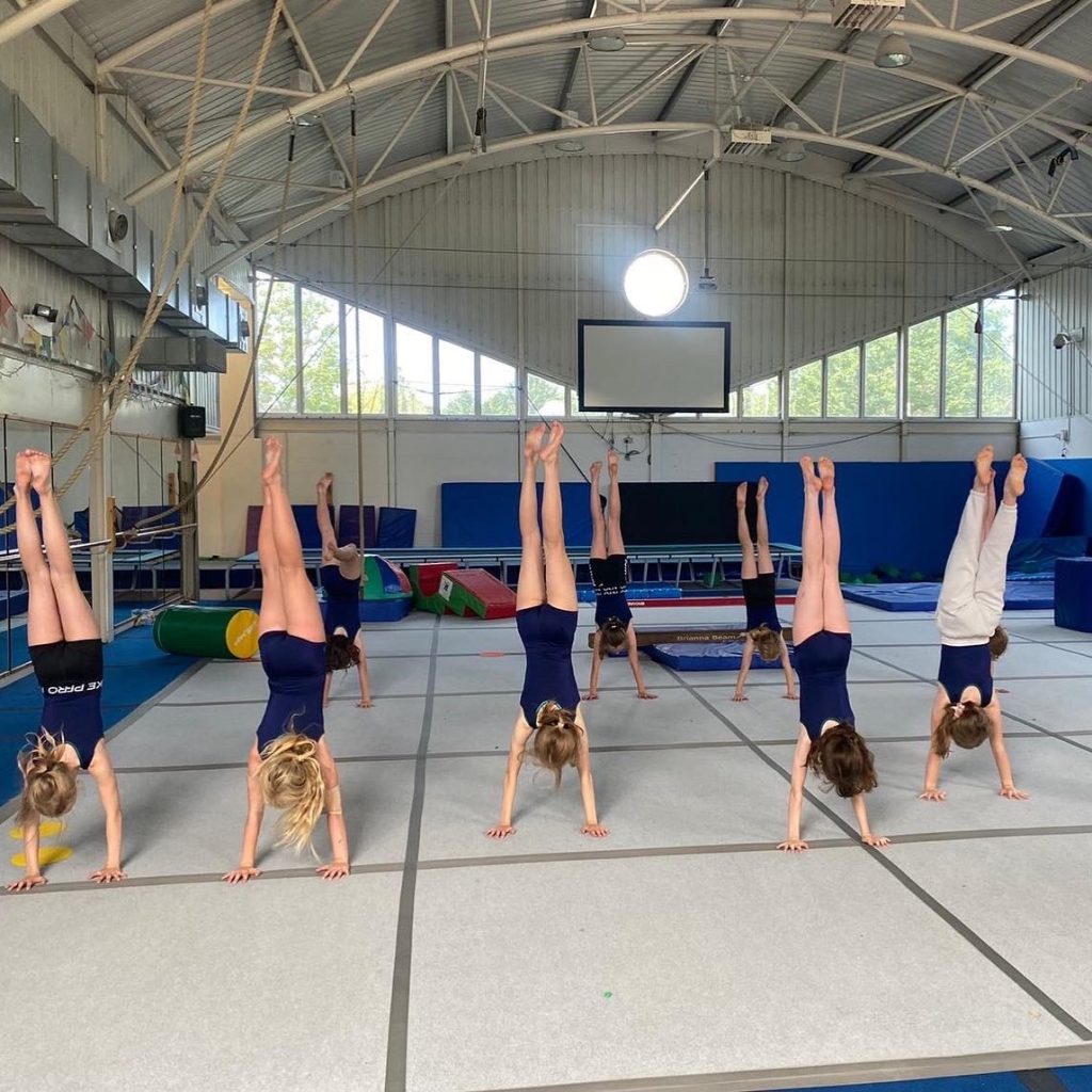 group of gymnasts all doing a handstand